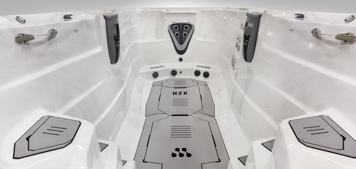 Binnenaanzicht van een zwemspa zonder water, waarop de Velocity-injectorplaat te zien is.