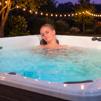Een vrouw die zich ontspant in een zwemspa met massagestralen.