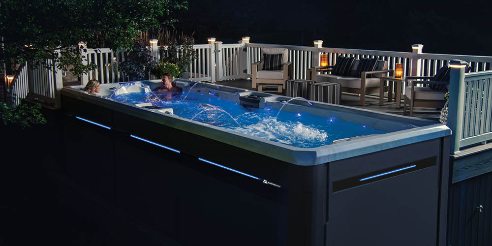 De H2X Challenger-zwemspa ’s avonds naast een terras.