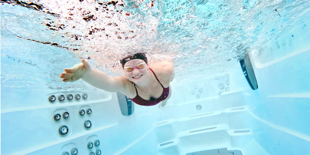 Onderwaterfoto van een vrouw die in het water zwemt.