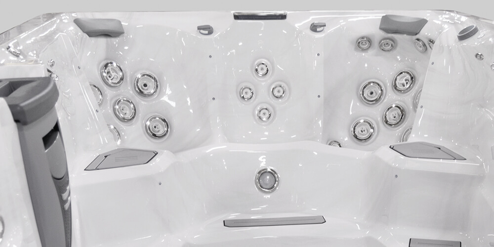 Blik op de binnenkant van een H2X Fitness-zwemspa zonder water, met de nadruk op de jets.