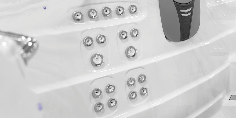 Blik op de binnenkant van een H2X Fitness-zwemspa zonder water, met de nadruk op de jets.