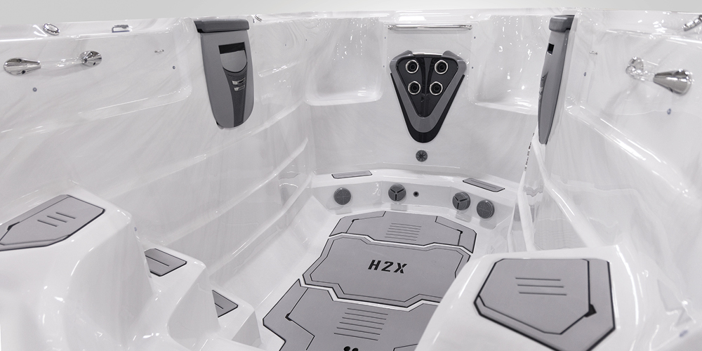 Blik op de binnenkant van een H2X Fitness-zwemspa zonder water, met de nadruk op de jets.