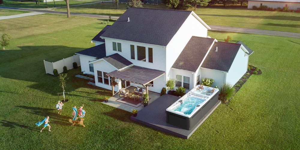 Een droneopname van de achtertuin van een woning, met daarin een zwemspa.