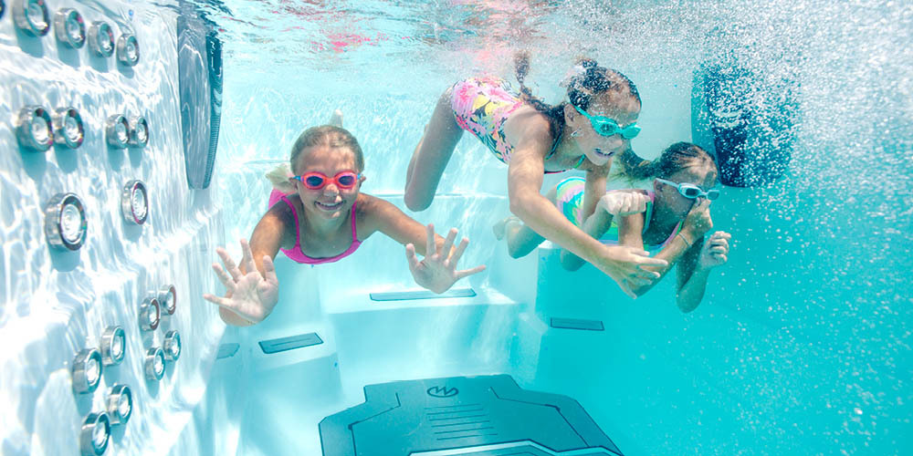 Onderwateropname van kinderen die genieten van een zwemspa.